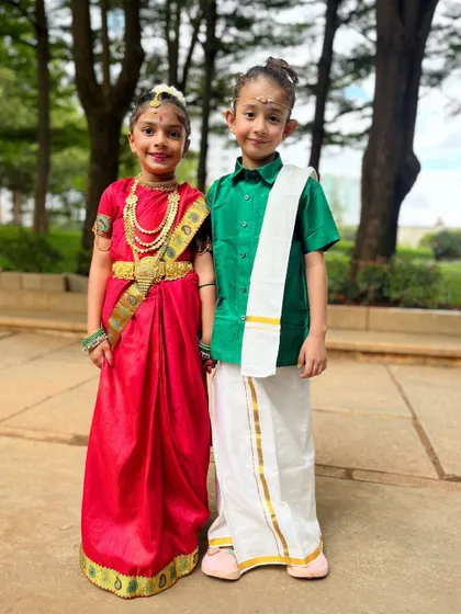 Culture is the arts elevated to a set of beliefs. These two students stand proudly in their traditional outfits, a beautiful representation of their heritage.