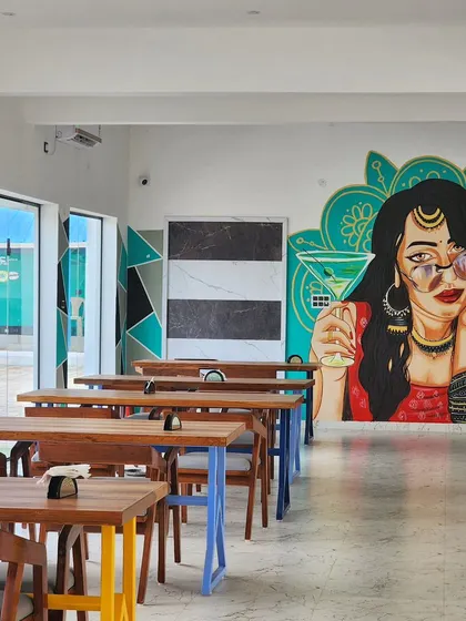 A wide view of the dining area at Nueva Cafe, where our modern desi pop art mural serves as a stunning focal point.