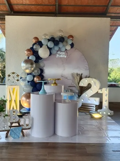 A cool and contemporary 21st birthday setup outdoors, using a color palette of navy blue, white, and chrome with minimalist props.