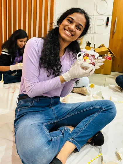 A smiling employee shows off the colorful mug she decorated during a corporate event. These workshops provide a much-needed creative break and a fun, personalized souvenir.