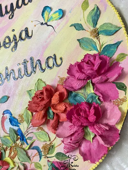 This personalized name board features a little sculpted bird perched among the roses. Adding small details like this makes each piece a one-of-a-kind artwork that reflects the family's personality.