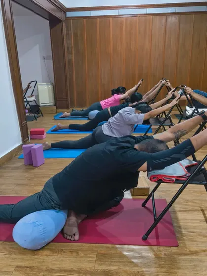Have a restful weekend. Students in a supported pigeon pose using chairs and bolsters, which allows for a deep yet gentle release of the hips.