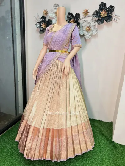 A full-length view of the lavender and gold half-saree, showing its graceful flow and the stylish gold belt that cinches the waist. This is a perfect blend of traditional Langa Voni style and modern design.