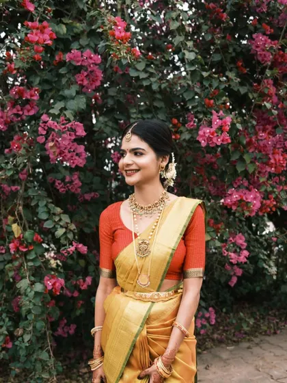 An outdoor shot of the bride against a backdrop of bougainvillea. Her natural-looking makeup and bright smile create a beautiful, fresh bridal portrait.