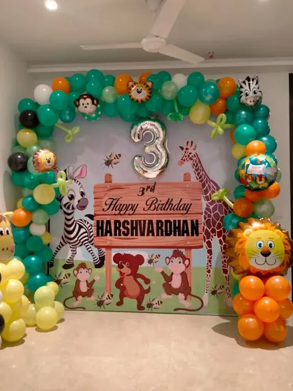 A cute jungle theme for a third birthday with a custom backdrop and animal foil balloons.