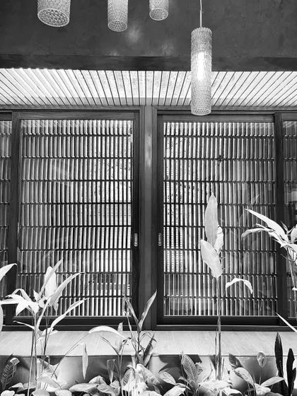 The graphic quality of the window screens and hanging lights is emphasized in this black and white composition.