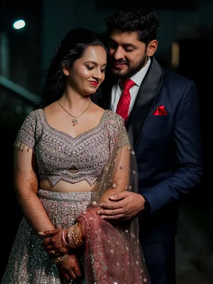 An elegant reception portrait of the couple. The dramatic lighting and their classic attire create a sophisticated and glamorous look.