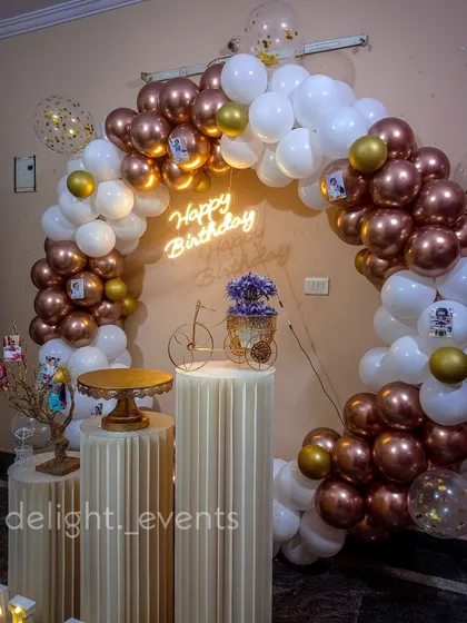 This elegant birthday decoration features a full ring balloon arch with on-trend chrome and white balloons. We added a custom neon sign and classic fluted pedestals to create a sophisticated and picture-perfect spot for celebrating.