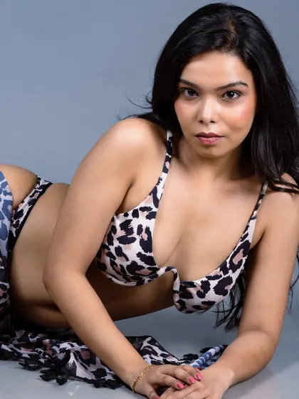 A close-up of the model in the animal print bikini, with a direct and confident gaze.