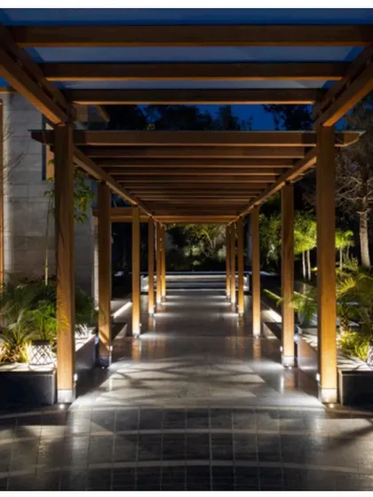The pergola walkway lit up at night. The ground-level lighting creates a safe and visually stunning path, enhancing the connection between the different areas of the property.