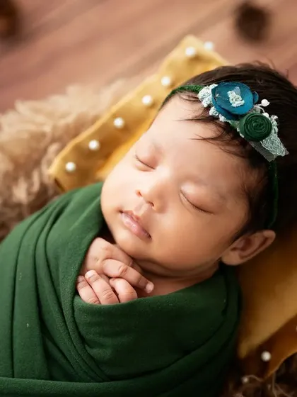 A close-up portrait of the sleeping baby's face, highlighting her delicate features.