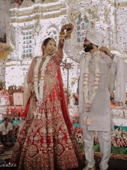 A moment of pure celebration after the varmala exchange, with confetti raining down on the happy couple.