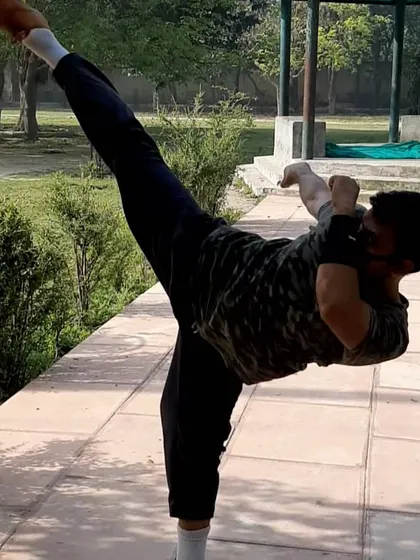 To teach powerful kicks, I maintain my own flexibility and strength. This is a demonstration of a high side kick, a fundamental move in martial arts that requires open hips and excellent balance.
