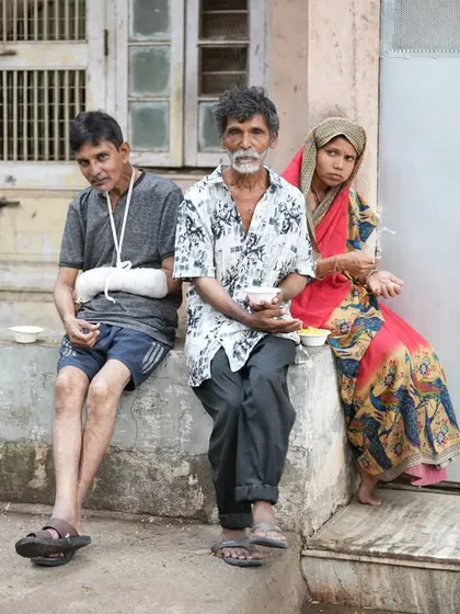 A family sits together to eat, finding comfort and support through our Annam Brahma program.
