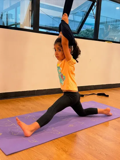Using the aerial hammock for support while practicing a split. This is a great way for kids to work on their flexibility and achieve deeper stretches.