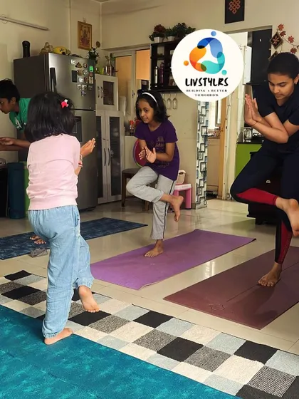 Kids of different ages practice a balancing pose together. My classes are inclusive and encourage peer support and fun.