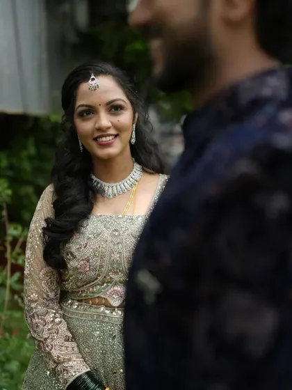 A candid shot of the bride looking at her groom. Her makeup is soft and glowing, and her hair is styled in beautiful, loose waves.