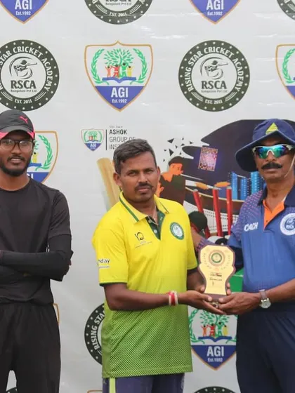 A player proudly accepts his trophy at the conclusion of a match, with teammates looking on.
