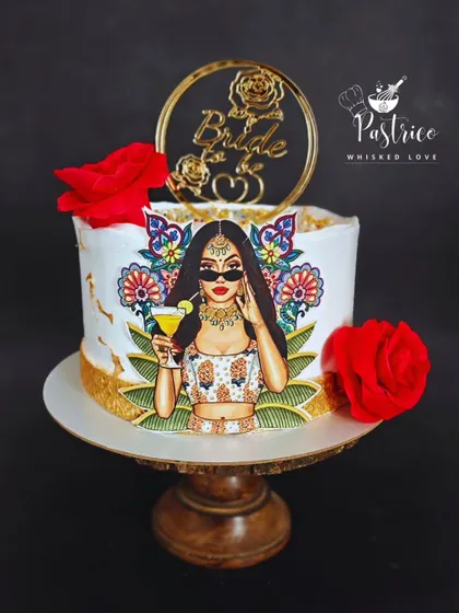 A chic "Bride to be" cake featuring a stylish edible print, gold accents, and fresh red roses for a modern bridal shower.