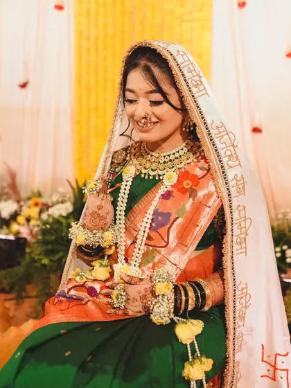 A full view of this bride's Haldi look, showing how our custom floral jewellery, including the long floral garland, complements her traditional Maharashtrian attire.