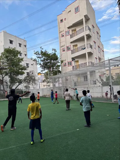 A coach demonstrates a technique, providing hands-on guidance to help every child improve their football skills.