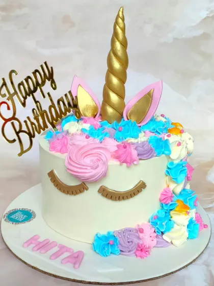 A simple and sweet unicorn cake with colorful buttercream swirls and sleepy golden eyes. It's a classic design that brings a touch of magic to any birthday.