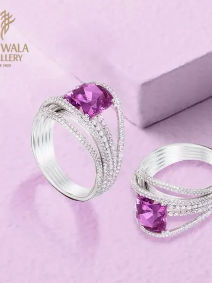 A modern design featuring two cushion-cut purple gemstones on a split-shank diamond band. The clean lines and bold color make this a sophisticated and contemporary choice.