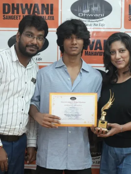 A student with his mother and teacher, celebrating his success.