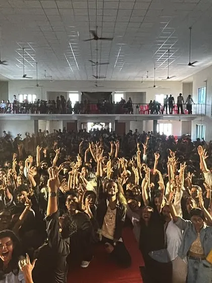A pack-up photo with the entire student body at St. Paul's College, all with their hands in the air.