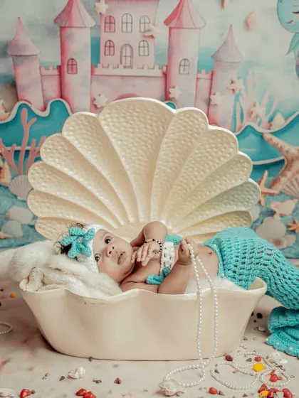 A pearl from the ocean. This mermaid theme is so magical, with an underwater castle backdrop and a seashell for your baby to rest in.