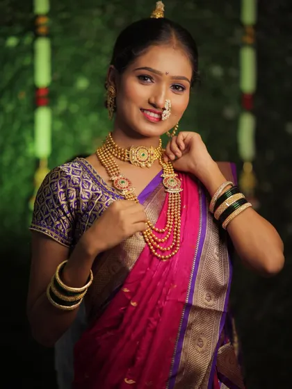 A happy bride-to-be, fully styled in her Maharashtrian engagement attire. The look features a beautiful choker and long necklaces that are characteristic of our culture.