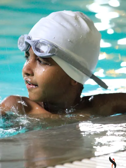 A moment of focus and determination. This swimmer is catching his breath, ready for the next lap in a demanding training session.