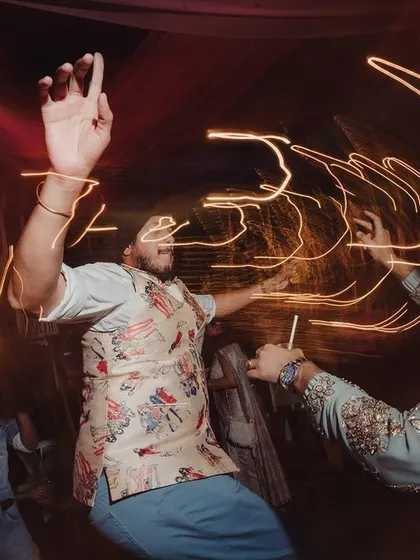 The energy on the dance floor is what makes a celebration unforgettable. This shot, with its dynamic light trails, captures the pure joy and abandon of guests dancing the night away at a Mehendi & Cocktail party.