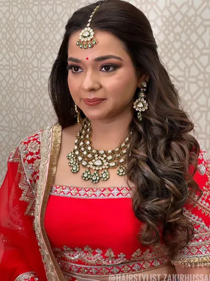 A classic half-up, half-down style with soft waves, perfect for a traditional bride. The style keeps the hair away from the face to highlight the maang tikka.