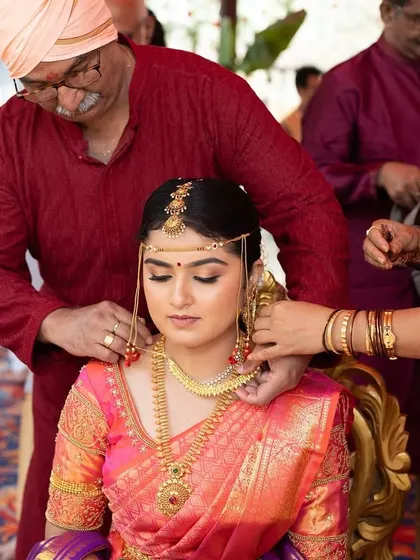 The sacred moment of the groom tying the thaali. The bride's makeup remains flawless, highlighting her serene expression.