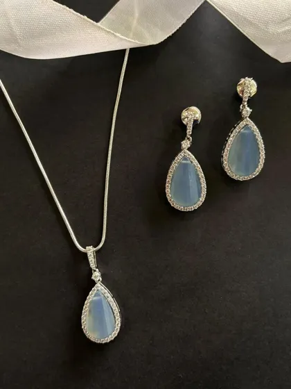 Celebrate the season with timeless elegance. This pendant and earring set, featuring a soft blue stone surrounded by a halo of diamonds, is one of my top festive picks.