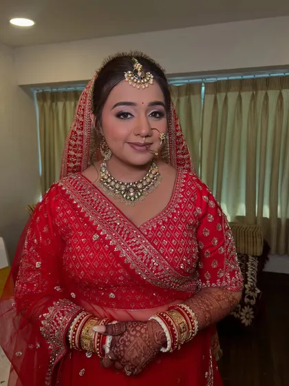 A classic bridal pose. The makeup is traditional yet modern, with a focus on flawless skin and bright eyes.