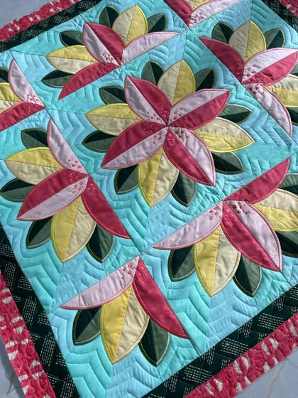 Another close-up of the "Big Bloom" quilt, showing the detailed quilting around the flowers.