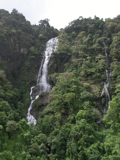A magnificent waterfall cascading down a mountain, seen from a distance. The scale of the falls in the Western Ghats during monsoon is truly awe-inspiring.