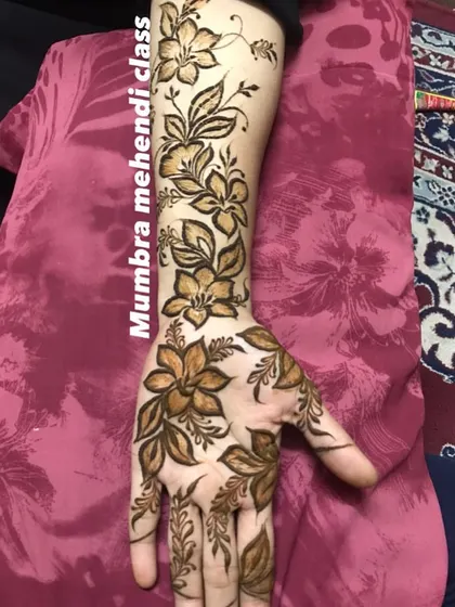 A Dubai floral design with flowers and leaves climbing up the arm.
