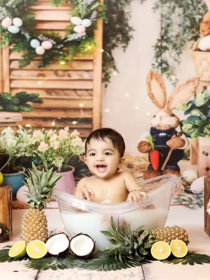 A vibrant and cheerful fruit bath session, perfect for a fun and unique toddler photoshoot. The colorful setup includes fresh fruits and whimsical props like Easter bunnies, creating a lively scene.