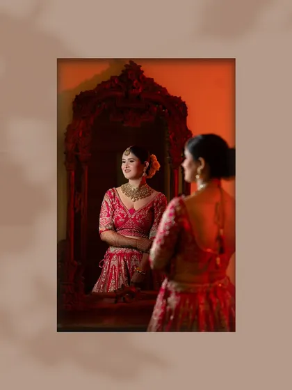 A moment of admiration. The bride looks at her reflection in an ornate mirror, a classic and elegant bridal shot.