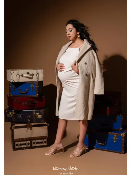 A chic and modern maternity look. The makeup is soft and natural, with a focus on glowing skin, complementing the casual yet stylish outfit.