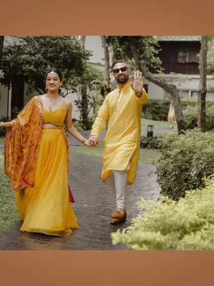 The couple walking hand-in-hand after their Haldi ceremony in Thailand.