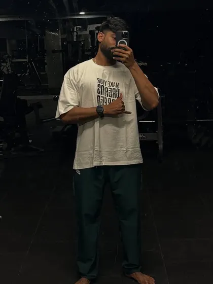 "Sweat is fat crying." A relaxed post-workout photo in an oversized tee, ready to crush more goals.