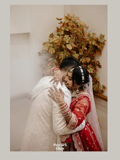 A tender hug between the bride and groom, a quiet moment of connection and reassurance amidst the grandeur of the wedding ceremony.