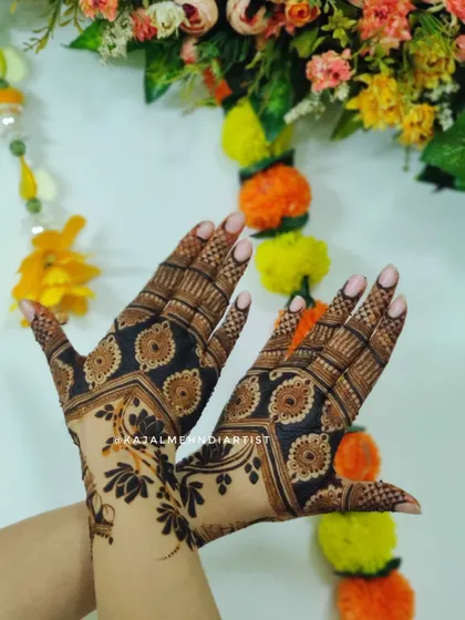 A designer backhand henna with a bold, modern aesthetic. The dark-filled patterns create a striking contrast, perfect for making a style statement.