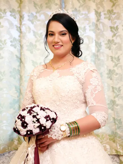 A smiling portrait of the bride, ready for her ceremony. The classic makeup and hair, paired with a beautiful tiara, create a look of timeless bridal elegance.