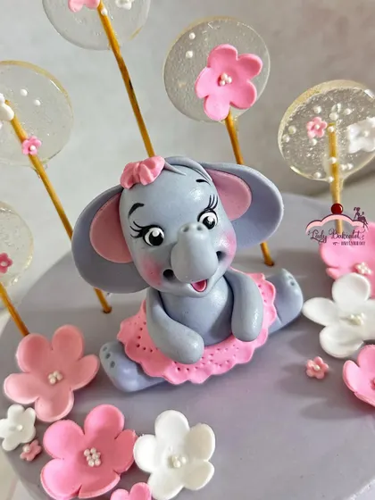 An ele-phantastic cake! This design features a lovely grey base with pink and white sugar flowers and an adorable baby elephant in a tutu.