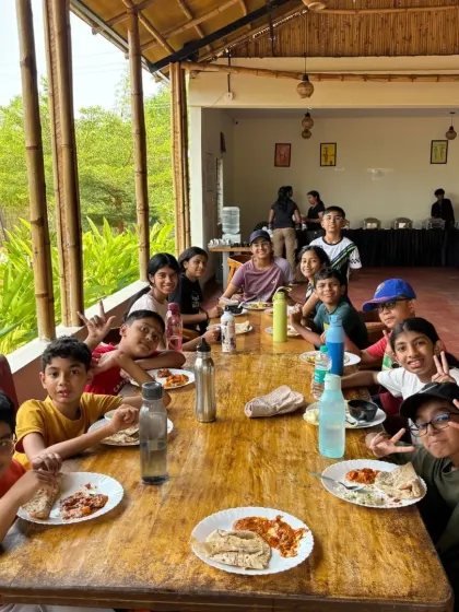 A happy group of campers enjoying a meal together. Shared meals are a great time for bonding and sharing stories from the day's adventures.